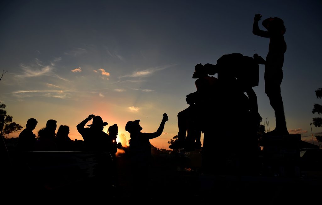 This photo taken on October 29, 2016 shows people drinking at sunset before a "Bachelor and Spinster" ball in the town of Ariah Park in western New South Wales.  Pick-up trucks, cowboy boots and a 24-hour booze-fuelled party in the Outback: welcome to modern-day dating in Australia's bush, where swiping right is not an option. - TO GO WITH Australia lifestyle social dating, FEATURE by Glenda KWEK   / AFP / Peter PARKS / TO GO WITH Australia lifestyle social dating, FEATURE by Glenda KWEK