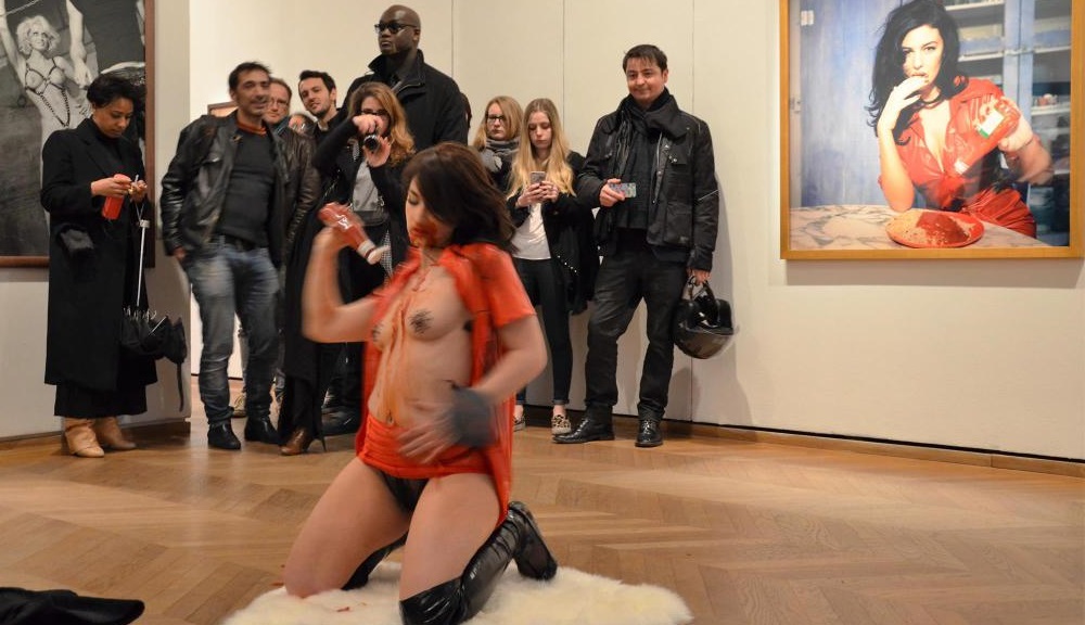 Performance de Déborah de Robertis près d'un cliché de Monica Bellucci, le 27 mars, lors d'une exposition consacrée à Bettina Rheims à la Maison européenne de la photographie à Paris. (photo DR)