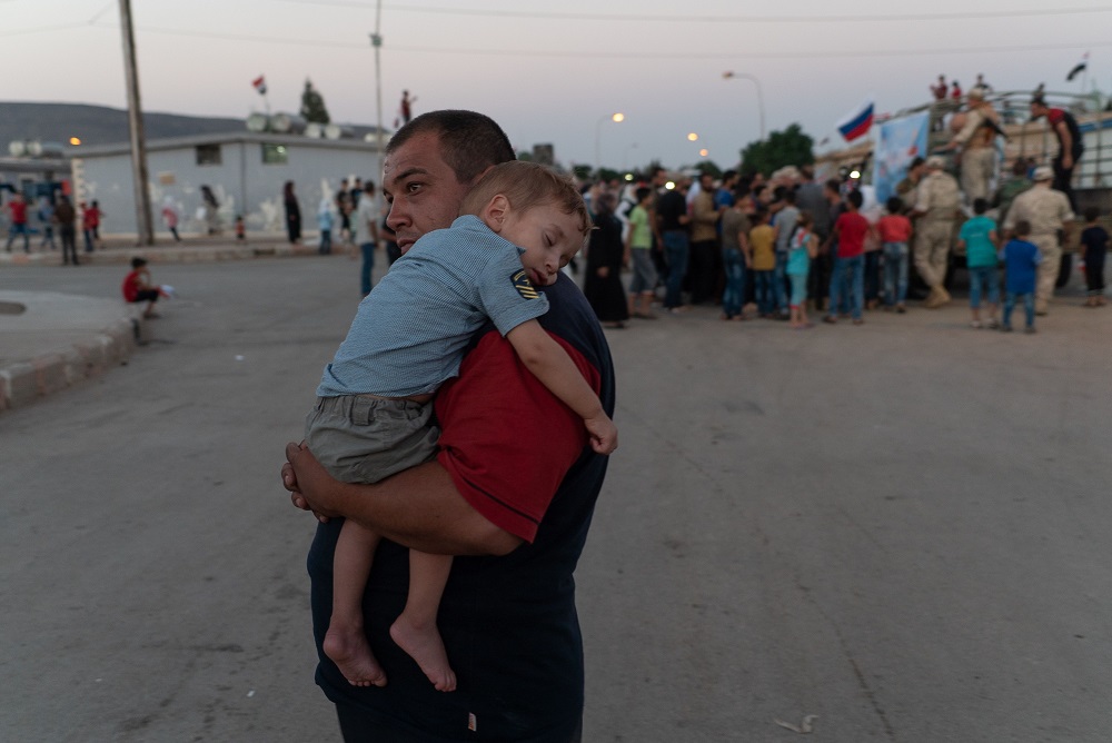 Des Syriens déplacés se rassemblent près d'un camion militaire russe le 13 août 2018 à Hirjillah, dans la banlieue sud de la capitale Damas, lors d'une visite guidée avec l'armée russe. (Photo : AFP)