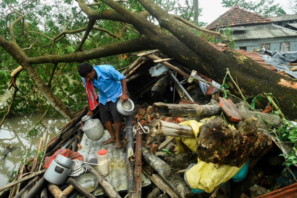 Un homme récupérant des objets de sa maison endommagée par le cyclone Amphan à Midnapore, au Bengale occidental. (photo AFP)