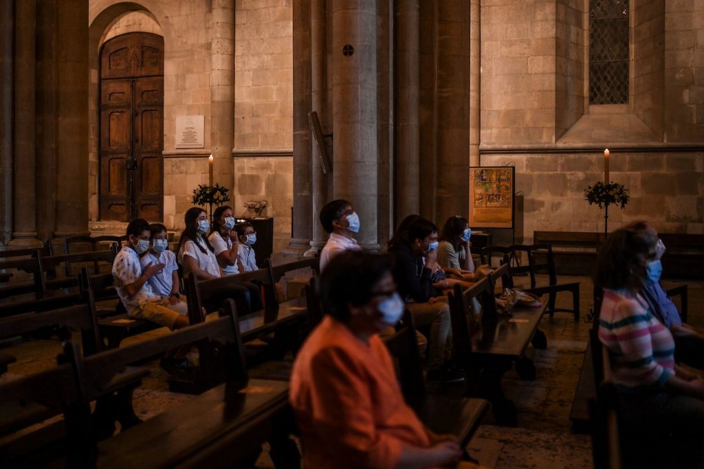 Believers wear face masks as they attend the first Sunday mass at Lisbon Cathedral on May 31, 2020, since the Portuguese government started easing lockdown restrictions, imposed to avoid the spread of the COVID-19 disease. (Photo by PATRICIA DE MELO MOREIRA / AFP)